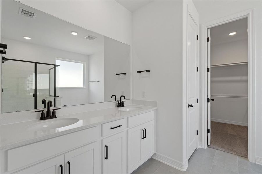 The en-suite bathroom offers a spa-like atmosphere with its elegant design, high end finishes, and tasteful lighting, creating a retreat within your own home.