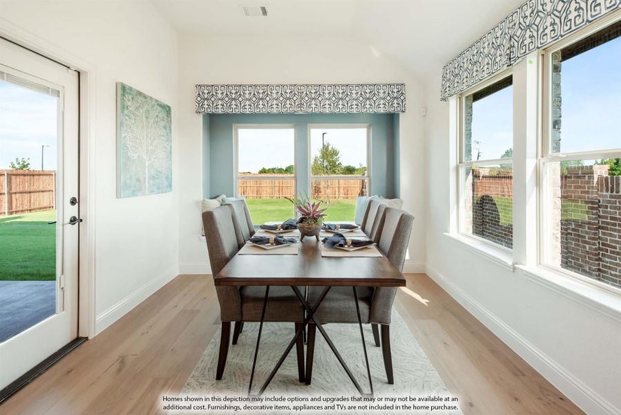 Bright dining room with wood table, gray chairs, hardwood floors, and large windows overlooking a backyard.