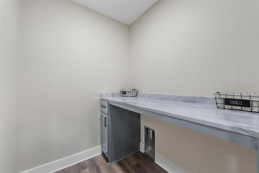 Laundry room featuring dark wood finished floors and baseboards