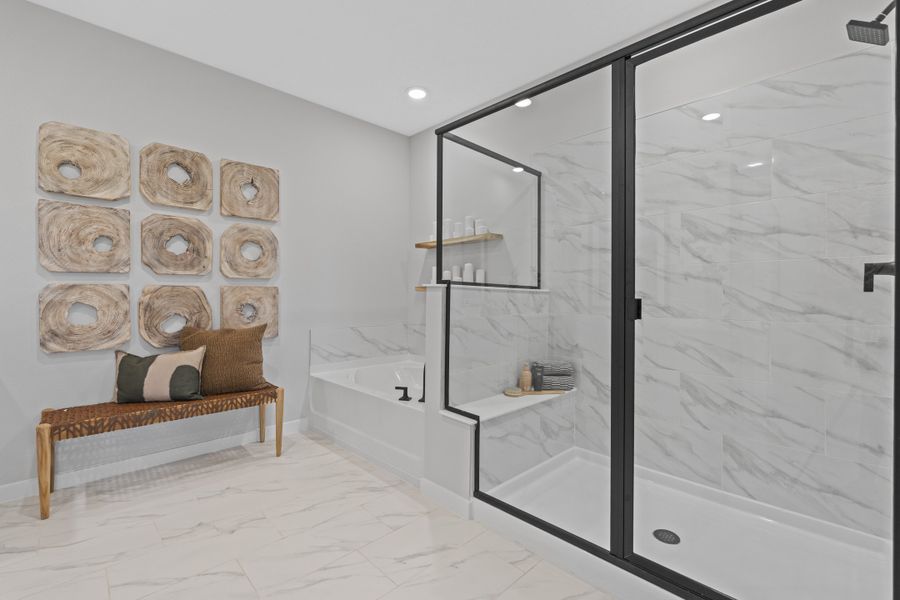 Kenai Model Home Primary Bathroom with Freestanding Tub and Glass Shower at Reserve East in Flagler Beach