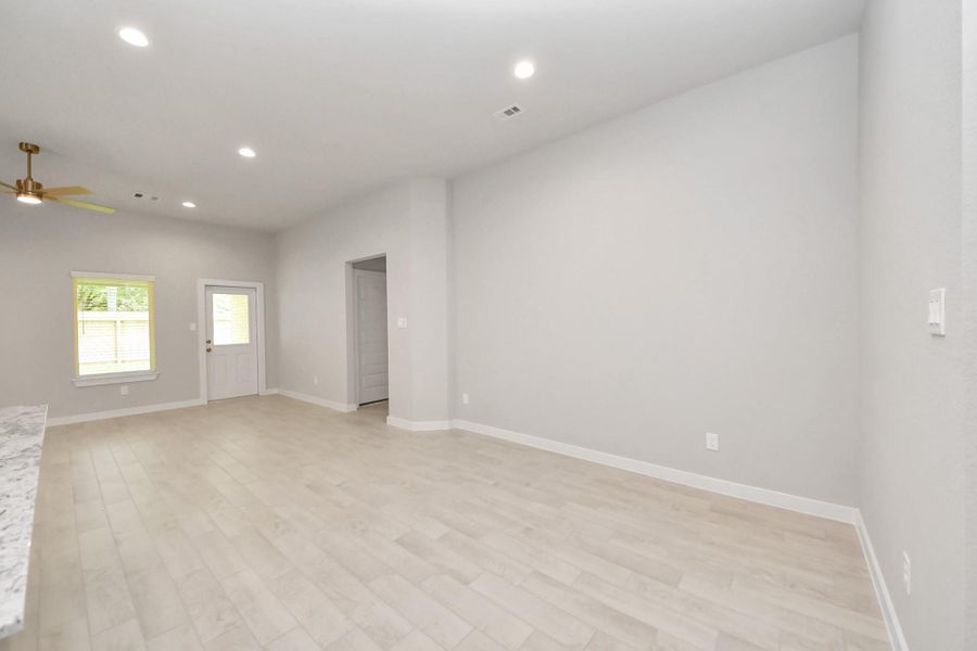 An inviting dining space seamlessly woven into the open concept, connecting the family room and kitchen. Revel in the stunning floors, soothing paint palette, and the crowning touch of a sleek chandelier – a perfect setting for shared meals and cherished moments. Sample photo of completed home with similar floor plan. Actual colors and selections may vary.