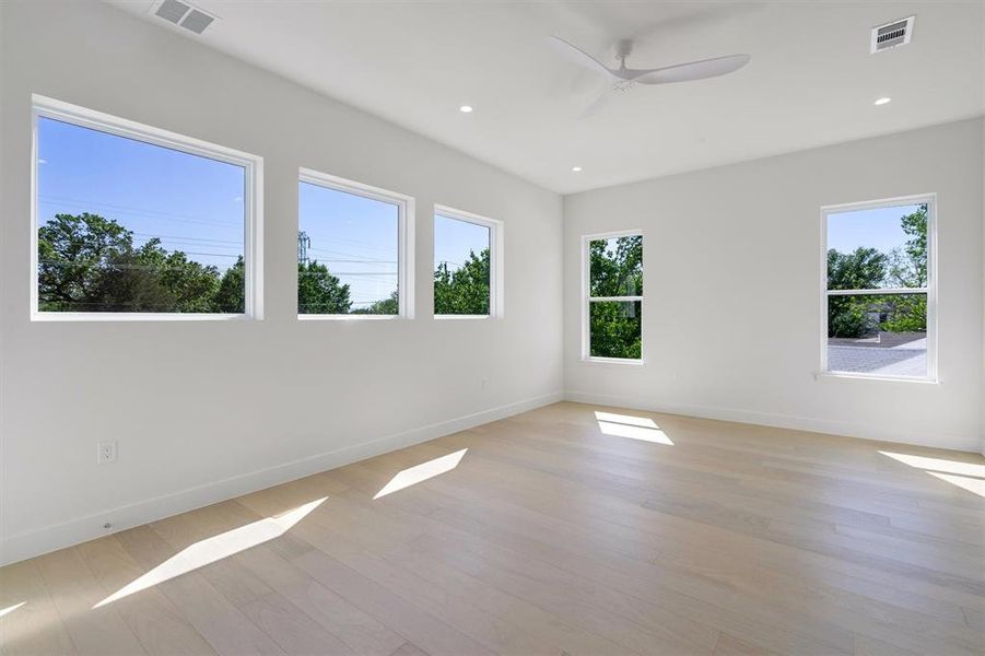 Unfurnished room with baseboards, visible vents, light wood-type flooring, and a ceiling fan