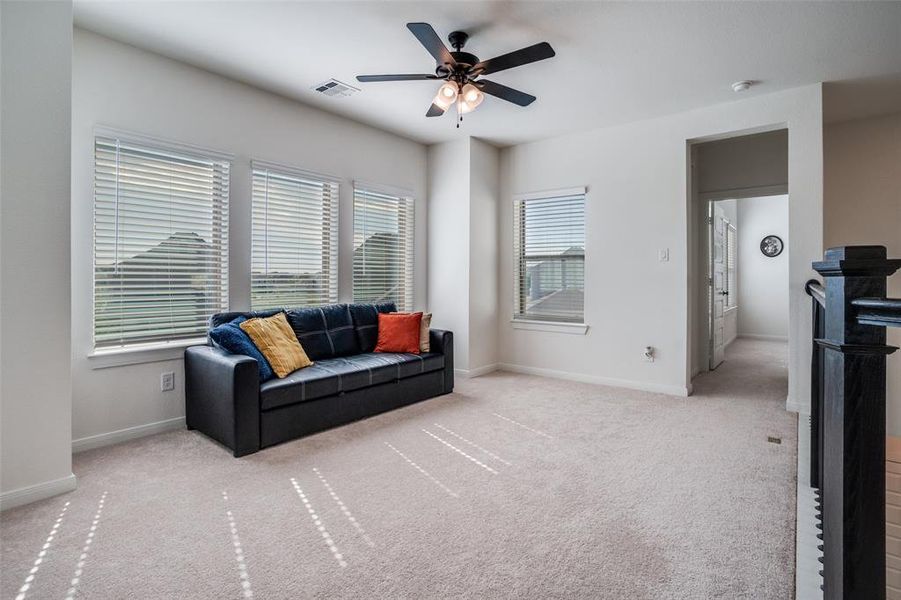 Living area featuring ceiling fan and light carpet