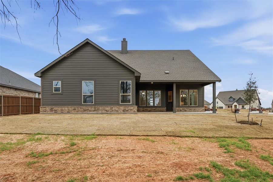 Rear view of property with brick siding, a patio, a chimney, and a shingled roof Rear view of property with brick siding, a patio, a chimney, and a shingled roof