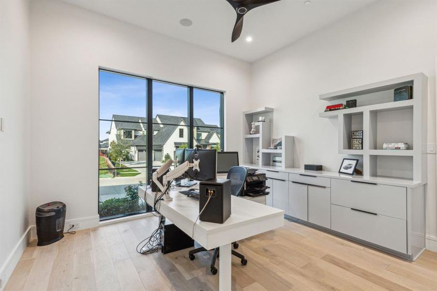 Office with a wealth of natural light, light wood-type flooring, and ceiling fan