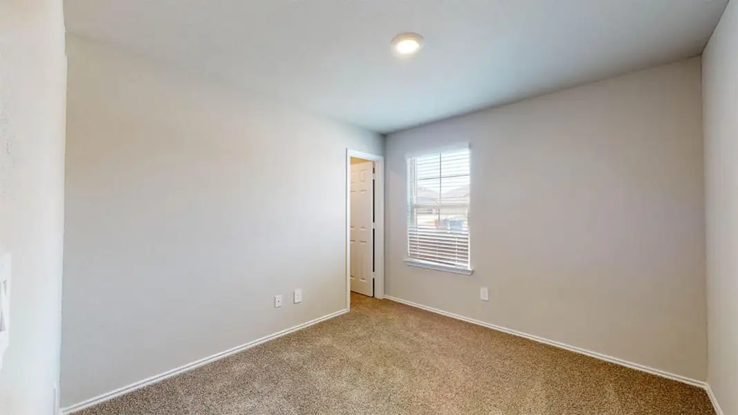 Spare room featuring carpet and baseboards