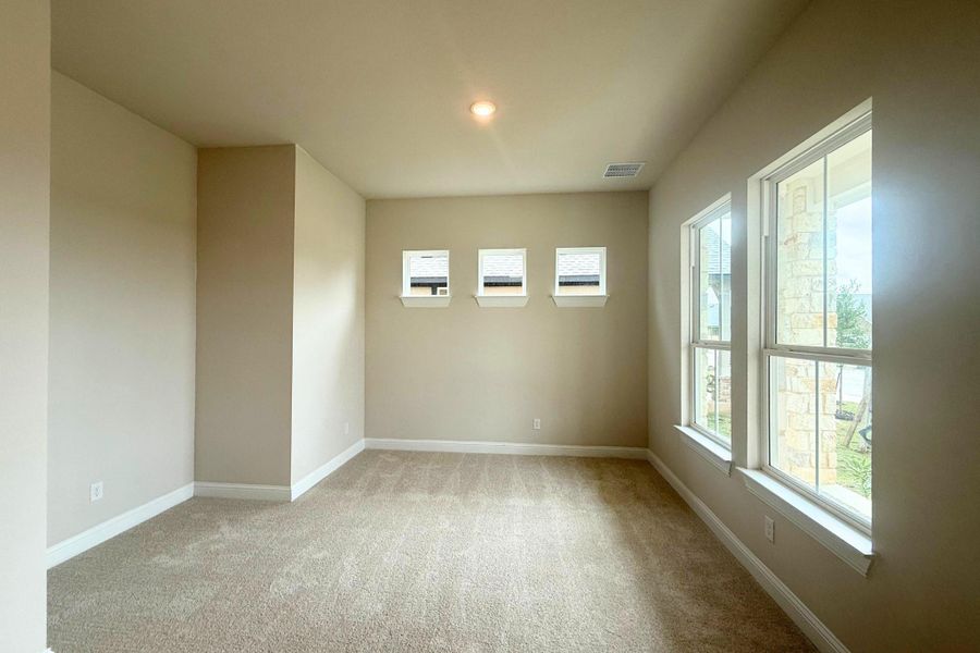 Spacious room featuring neutral carpeting, a recessed ceiling light, and multiple windows Spacious room featuring neutral carpeting, a recessed ceiling light, and multiple windows
