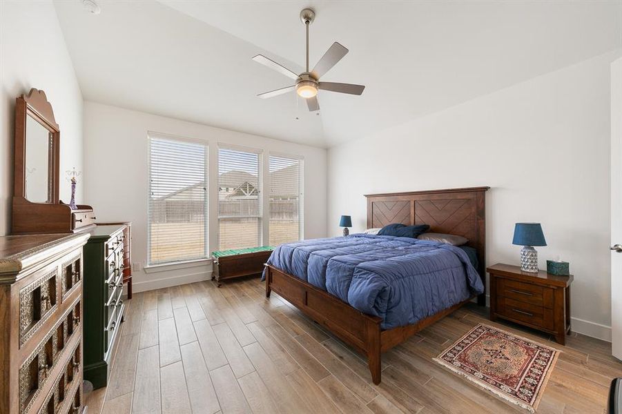 Spacious primary bedroom featuring wood-like tile flooring for style and durability