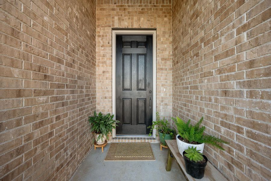 A classic paneled entry door, framed by brick walls, invites residents and guests inside. A classic paneled entry door, framed by brick walls, invites residents and guests inside.