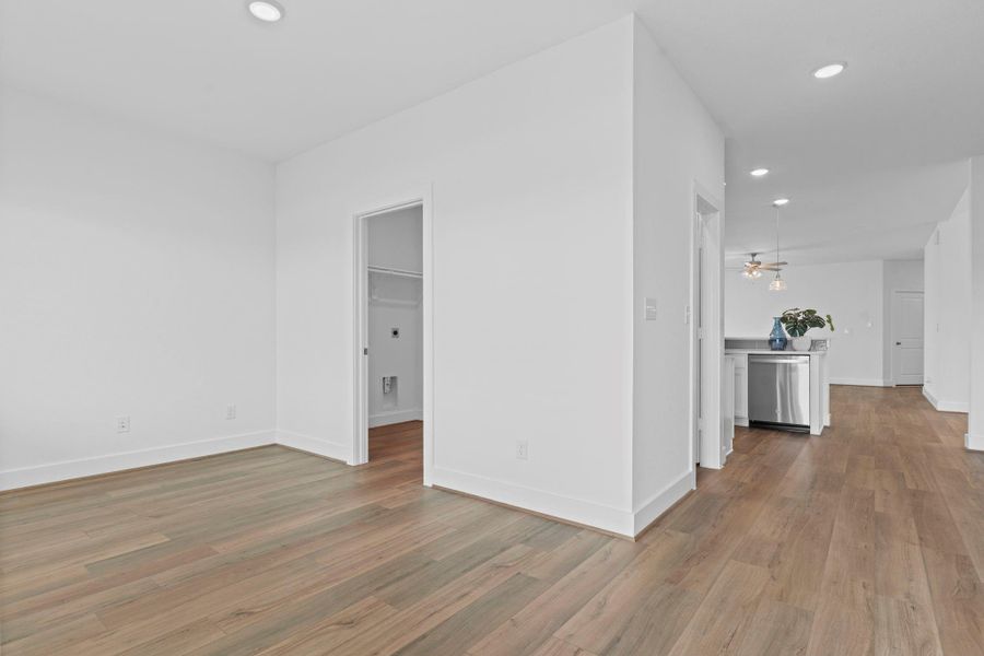 View of the private home office showcasing its spacious layout and wood look vinyl floors. The door leads directly to the utility room, offering added functionality and easy access within the home. **Image Representative of Plan Only and May Vary as Built**.