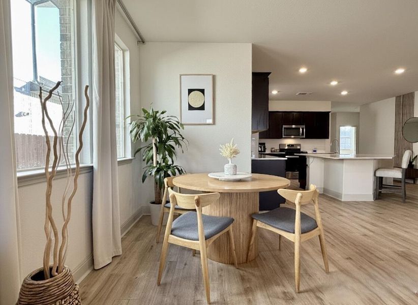 Dining space with light wood finished floors and recessed lighting