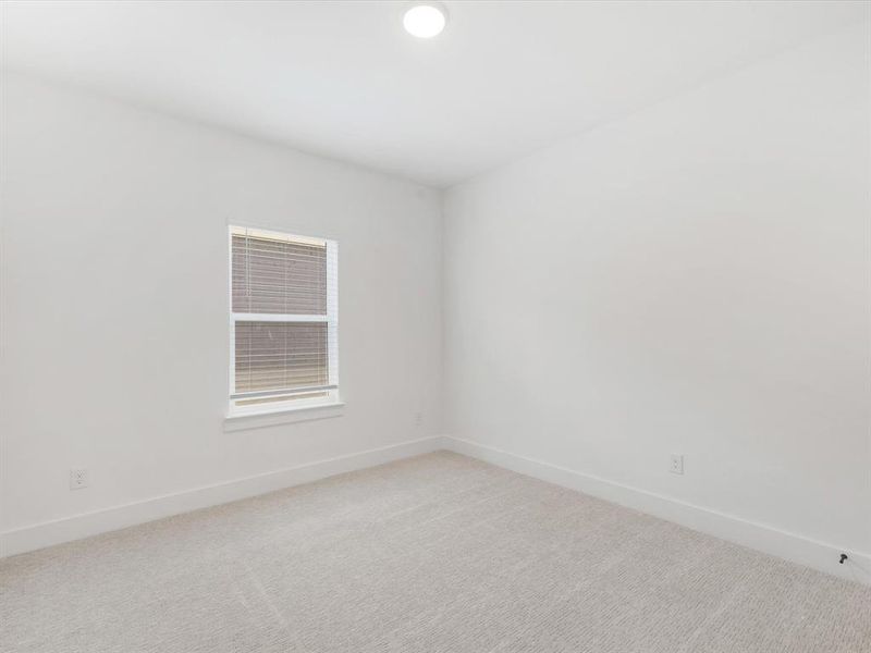 Bedroom 4 with baseboards and light carpet