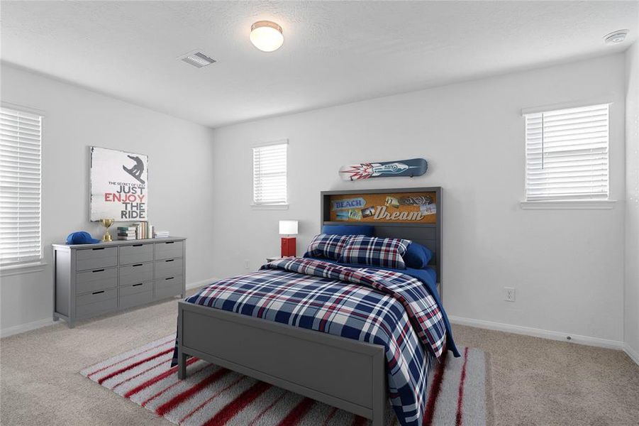 Secondary bedroom features plush carpet, custom paint, light, ample closet space, and a large window with privacy blinds.