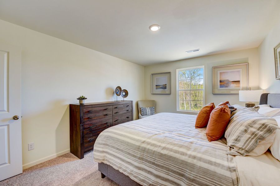 A bedroom with a bed and a chair. A bedroom with a bed and a chair.