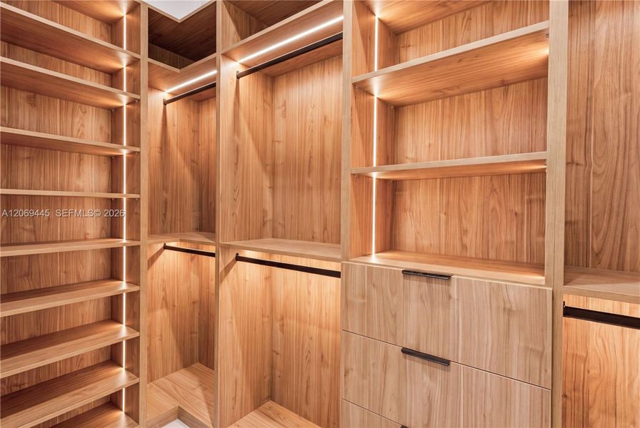 His-and-hers walk-in closets feature custom wood cabinetry, abundant shelving and generous hanging space. His-and-hers walk-in closets feature custom wood cabinetry, abundant shelving and generous hanging space.
