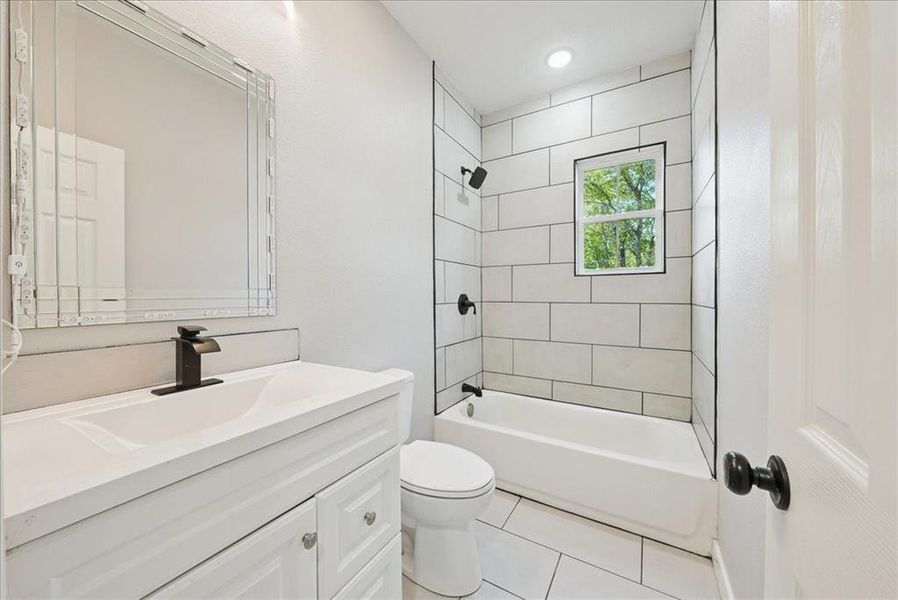 Bathroom featuring vanity, shower / washtub combination, and light tile patterned floors