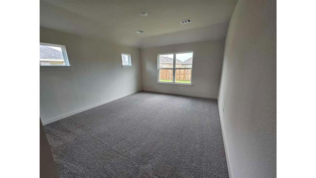 Spacious room featuring neutral carpeting, multiple windows, and recessed lighting Spacious room featuring neutral carpeting, multiple windows, and recessed lighting