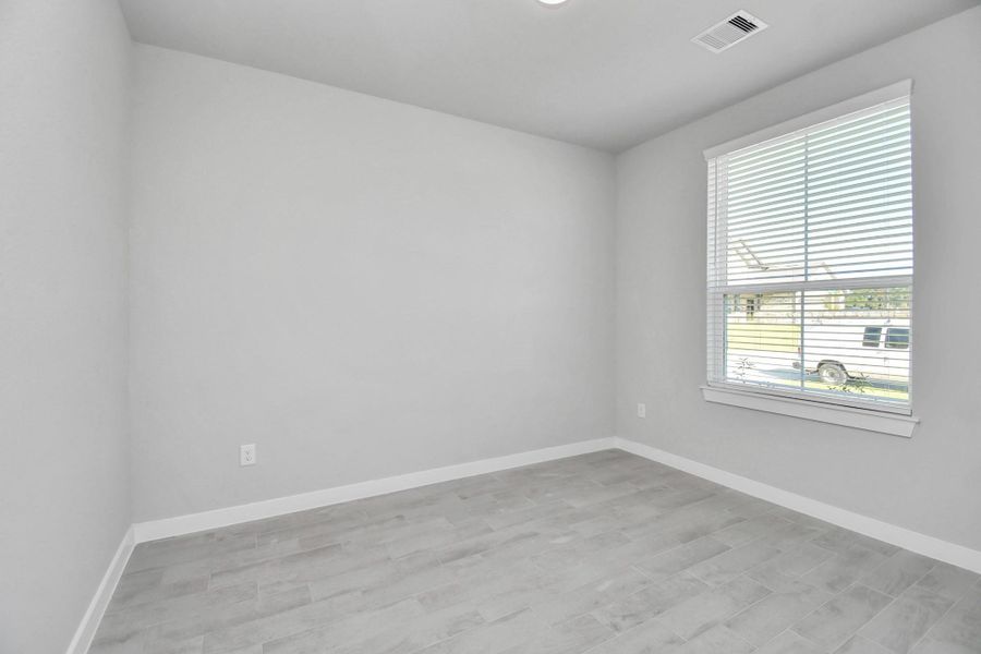Experience the perfect blend of sophistication and warmth in this home office, boasting elegant wood-look tile flooring and flooded with natural light from expansive windows and French doors. Sample photo of completed home with similar floor plan. Actual colors and selections may vary. Experience the perfect blend of sophistication and warmth in this home office, boasting elegant wood-look tile flooring and flooded with natural light from expansive windows and French doors. Sample photo of completed home with similar floor plan. Actual colors and selections may vary.
