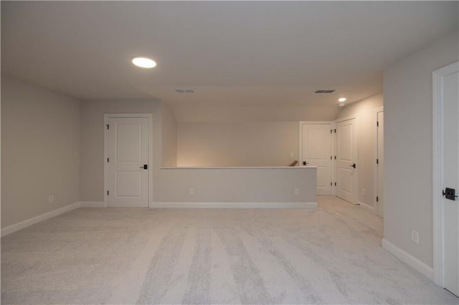 Empty room featuring recessed lighting and light carpet