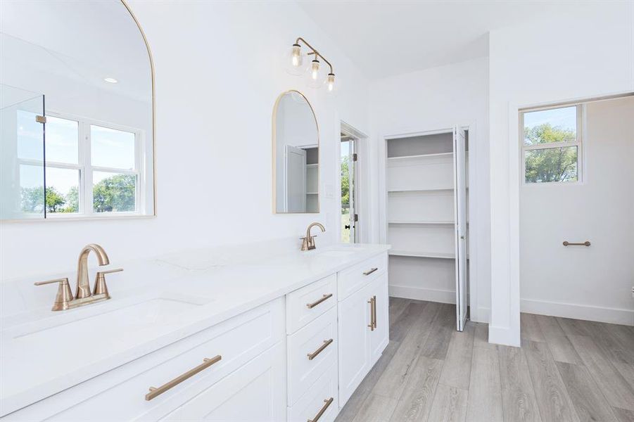 Bathroom with double vanity and wood finished floors