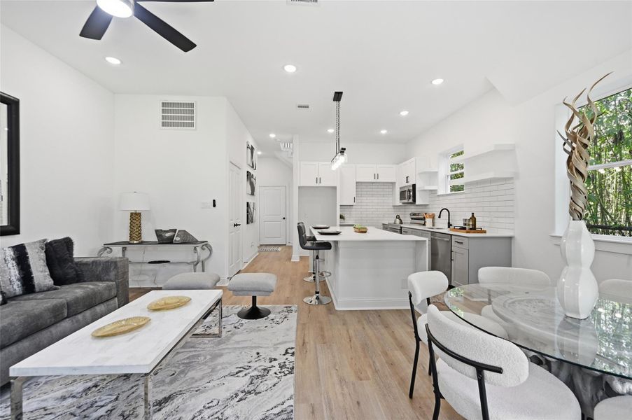 Open concept kitchen, dining and living room, with lots of natural light.