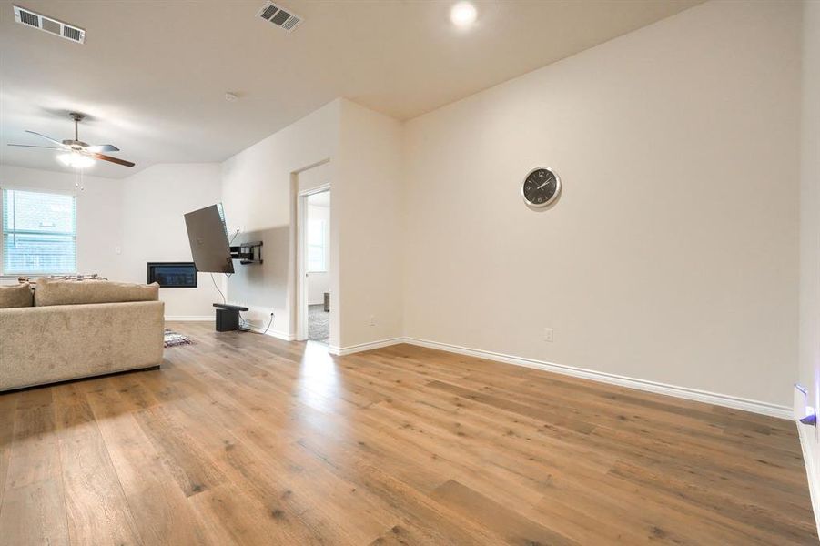 Living room with a ceiling fan, light wood finished floors, and healthy amount of natural light Living room with a ceiling fan, light wood finished floors, and healthy amount of natural light