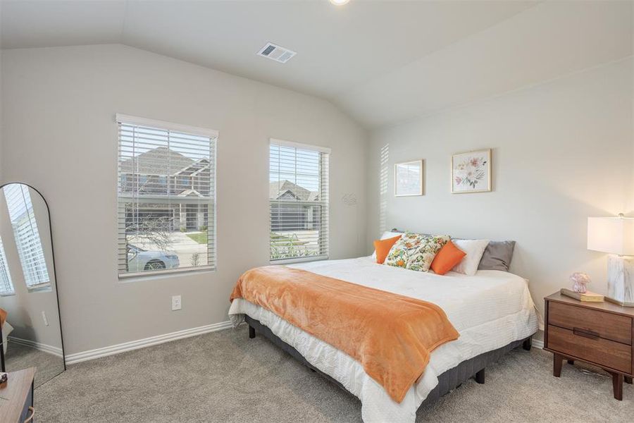 Bedroom with lofted ceiling and carpet floors Bedroom with lofted ceiling and carpet floors