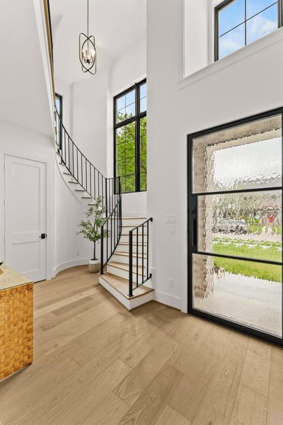 Welcome home! Light-filled entry with powder bath. Hallway leads to study, family room, and chef kitchen.