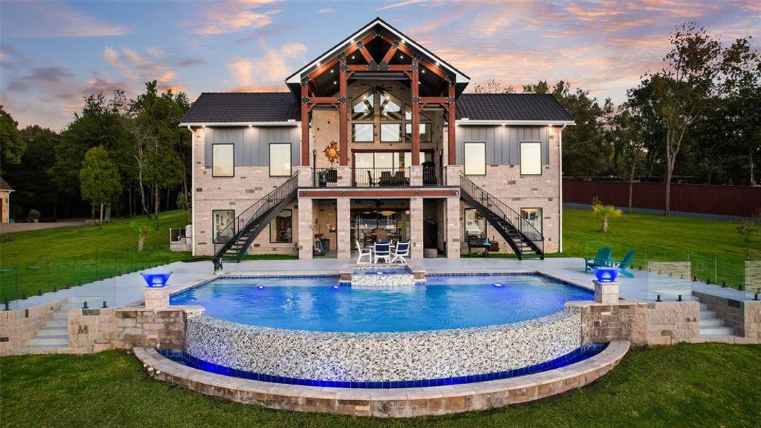 Back of property featuring stairway, a lawn, a patio area, and board and batten siding Back of property featuring stairway, a lawn, a patio area, and board and batten siding