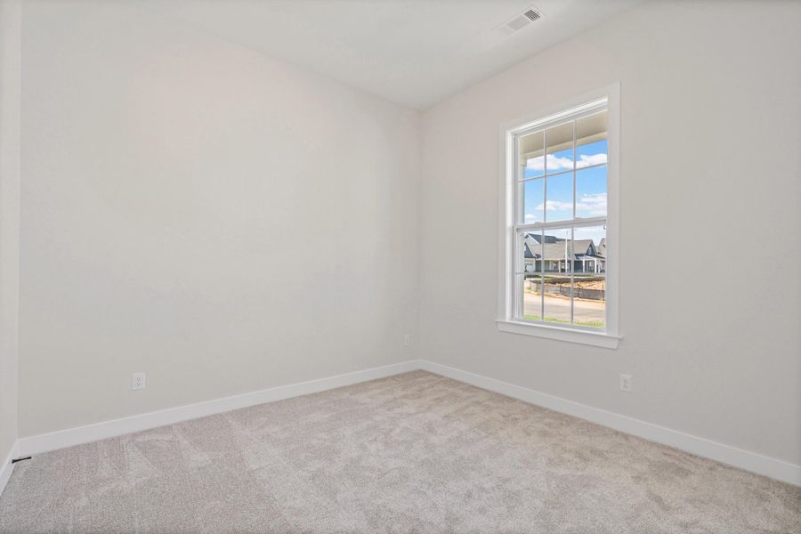 Wall-to-wall carpeting, single window with white trim, and light-colored walls