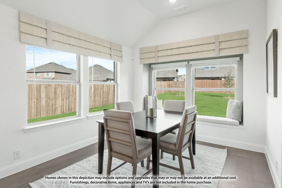 Dining area with dark table, four gray chairs, vaulted ceiling, and large windows with roman shades overlooking backyard Dining area with dark table, four gray chairs, vaulted ceiling, and large windows with roman shades overlooking backyard
