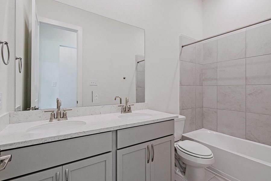 Full guest bathroom featuring a vanity and tub/shower combination Full guest bathroom featuring a vanity and tub/shower combination