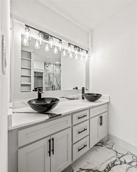 Bathroom featuring light marble finish floors, double vanity, and a marble finish shower Bathroom featuring light marble finish floors, double vanity, and a marble finish shower