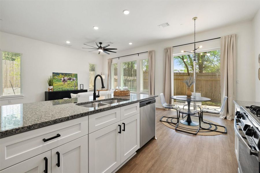 Kitchen featuring light wood-style floors, plenty of natural light, dark stone counters, and recessed lighting Kitchen featuring light wood-style floors, plenty of natural light, dark stone counters, and recessed lighting