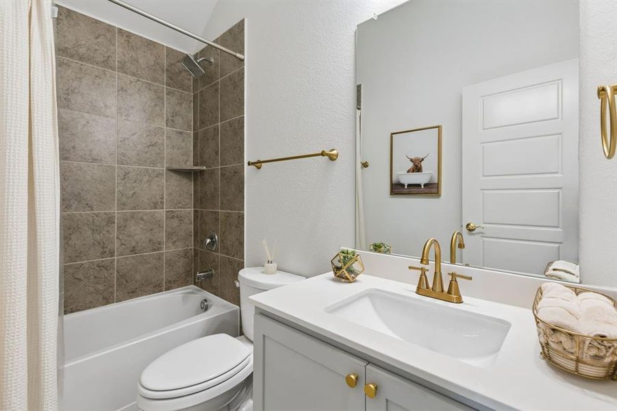 Bathroom featuring a single vanity with gold-tone hardware, a white countertop, and a matching gold-tone faucet