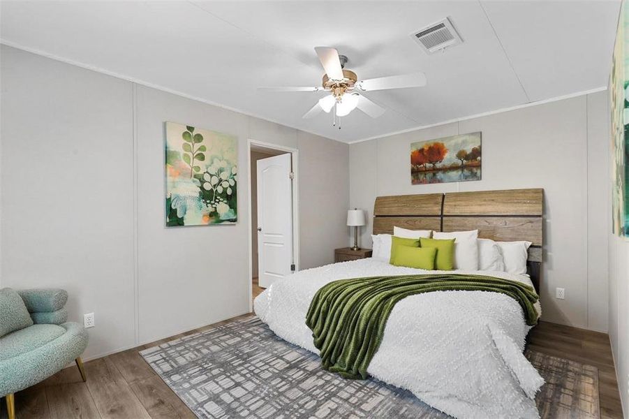 Bedroom with visible vents, crown molding, ceiling fan, and wood finished floors