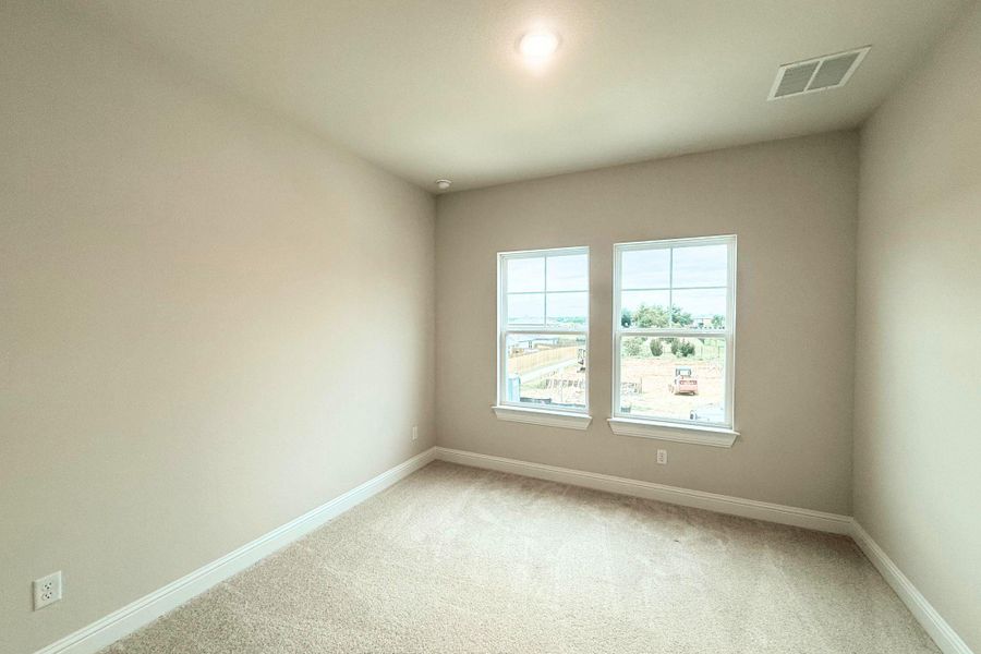 A well-lit bedroom featuring soft carpeting and a clear view of the surrounding landscape. A well-lit bedroom featuring soft carpeting and a clear view of the surrounding landscape.