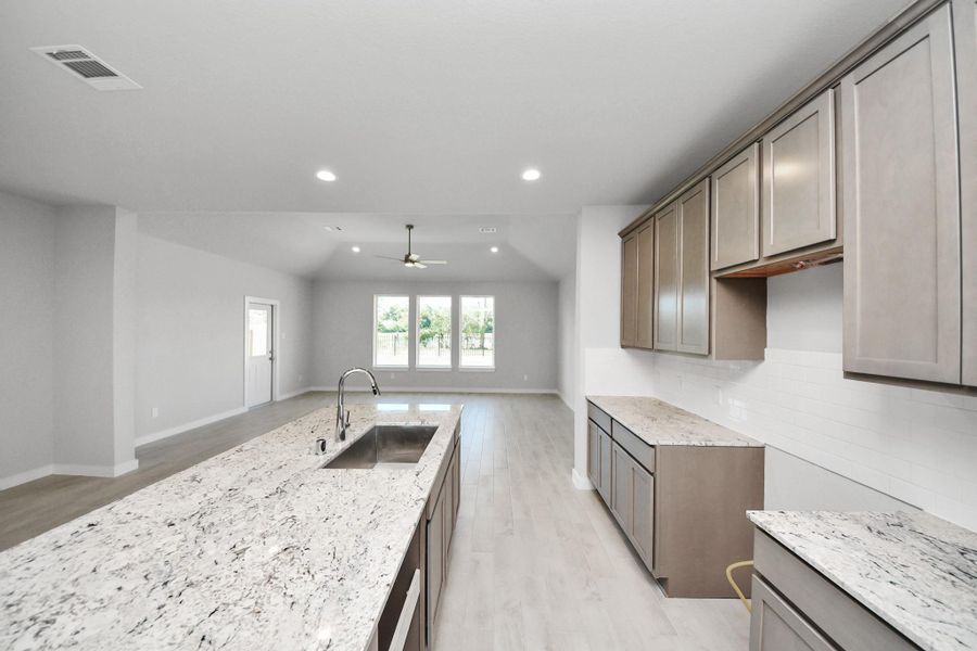 The extended counter area adds both practicality and style, making meal preparation a breeze. Every detail is thoughtfully designed to enhance the kitchen's functionality and aesthetic appeal. Sample photo of completed home with similar floor plan. Actual colors and selections may vary.