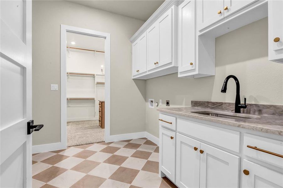 Laundry area featuring cabinet space, hookup for an electric dryer, hookup for a washing machine, and light flooring