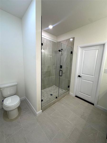 Bathroom with a shower with shower door and toilet