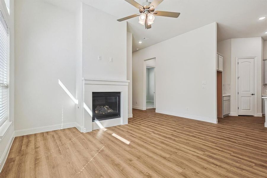 Unfurnished living room with light hardwood / wood-style floors and ceiling fan