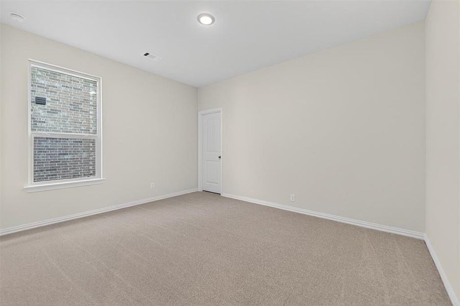 Spare room featuring light carpet and baseboards