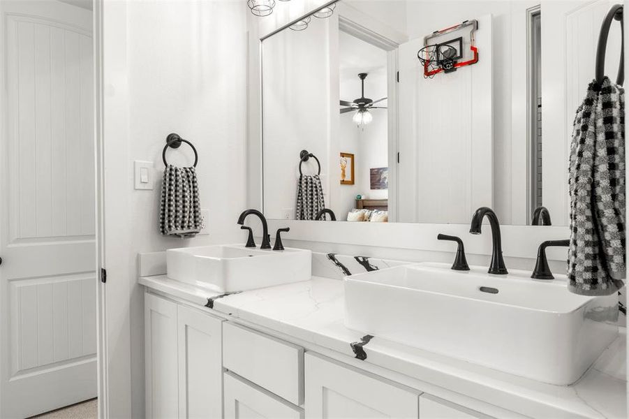 Jack and Jill bathroom with double vanity and ceiling fan