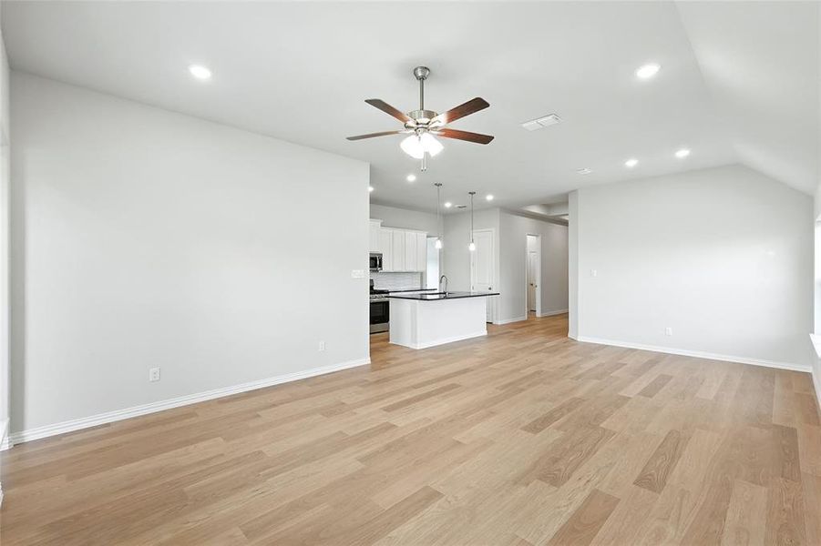 Unfurnished living room with light wood-style floors, a ceiling fan, and recessed lighting Unfurnished living room with light wood-style floors, a ceiling fan, and recessed lighting