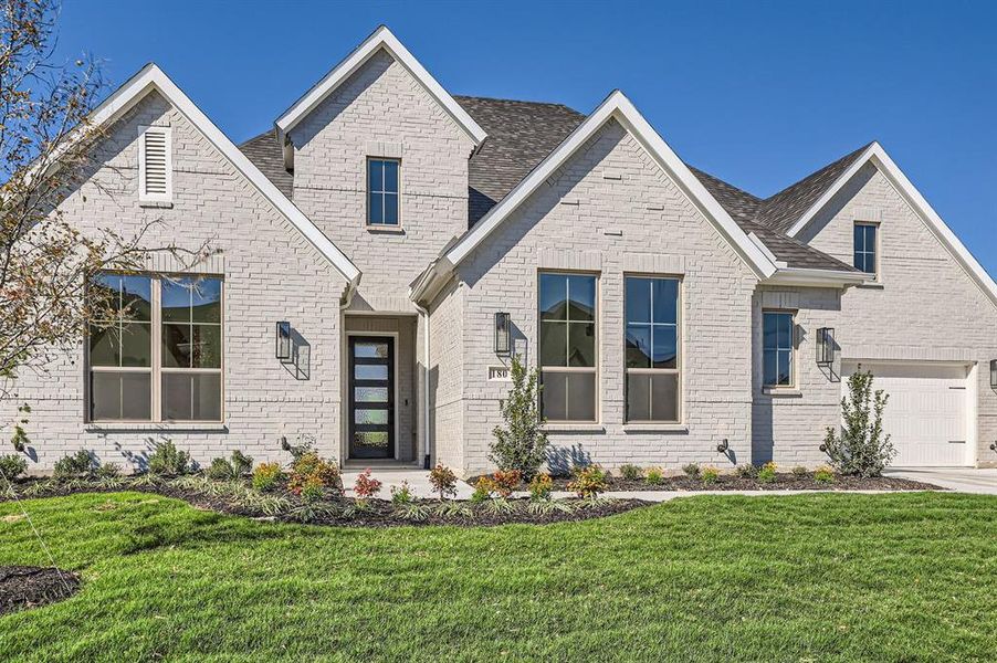 View of front of home with a garage and a front lawn