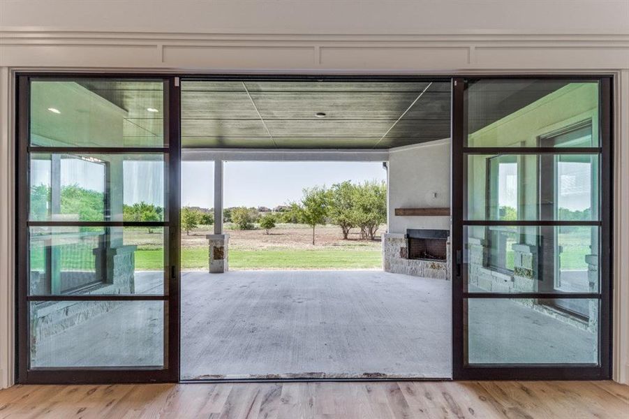 Large glass doors opening to the outdoor living area with a fireplace