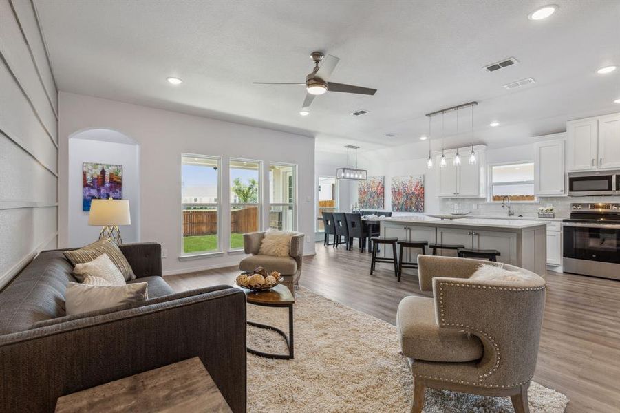 Living room with ceiling fan and light hardwood / wood-style floors