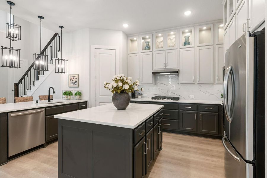 Kitchen includes a breakfast bar area, as well as a sizeable island with electrical outlet - cabinets offer under counter lighting as well.