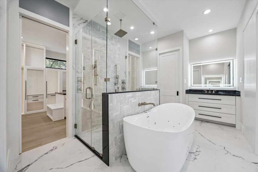 Flanking the space are dual vanities and private water closets for added convenience and privacy. Flanking the space are dual vanities and private water closets for added convenience and privacy.