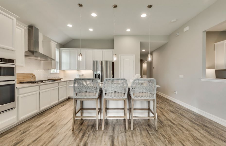 Spacious kitchen with eat-in bartop and pendant li